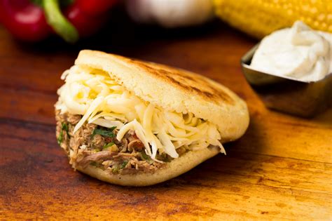 An arepa is a small, round sandwich made out of cornmeal, salt and water. It can be baked or grilled and stuffed with various fillings, such as avocado chicken salad for the reina pepiada …
